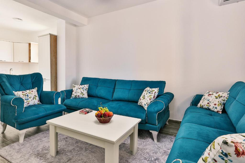 uma sala de estar com sofás azuis e uma mesa em Lux Apartmani Djukic em Bar