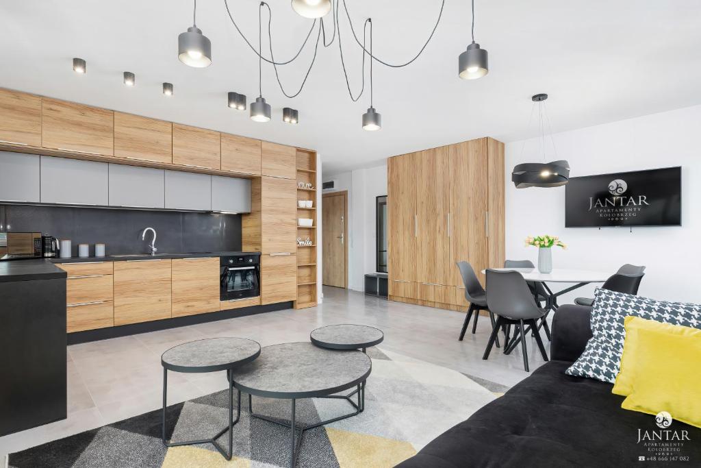 a living room with a couch and a table at Jantar Apartamenty - Perłowa Przystań in Kołobrzeg