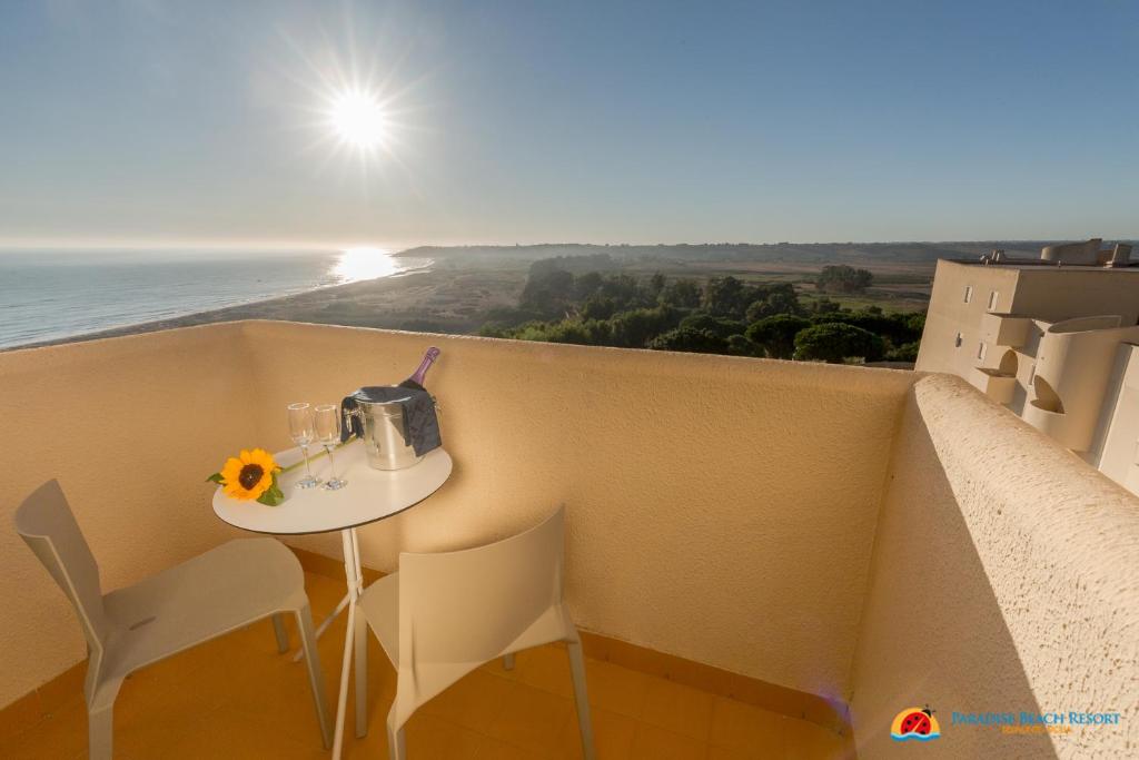 balcón con mesa, sillas y vistas al océano en Hotel Paradise Beach Resort, en Marinella di Selinunte