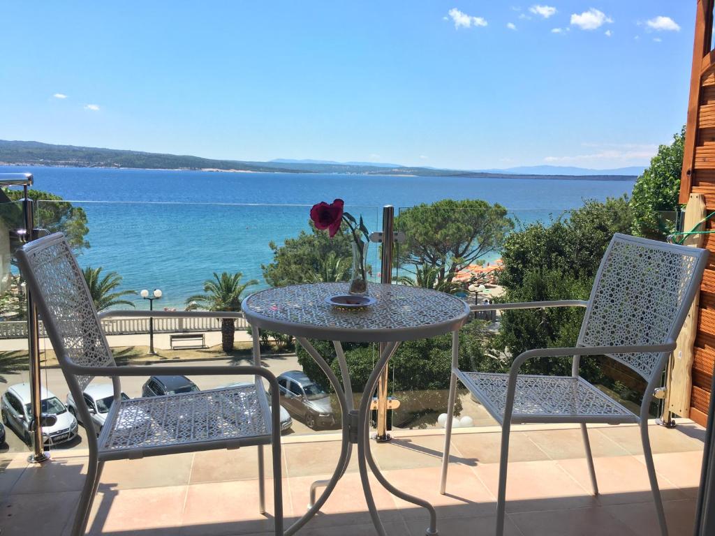 a table and chairs on a patio with a view of the ocean at Apartment Piko in Crikvenica