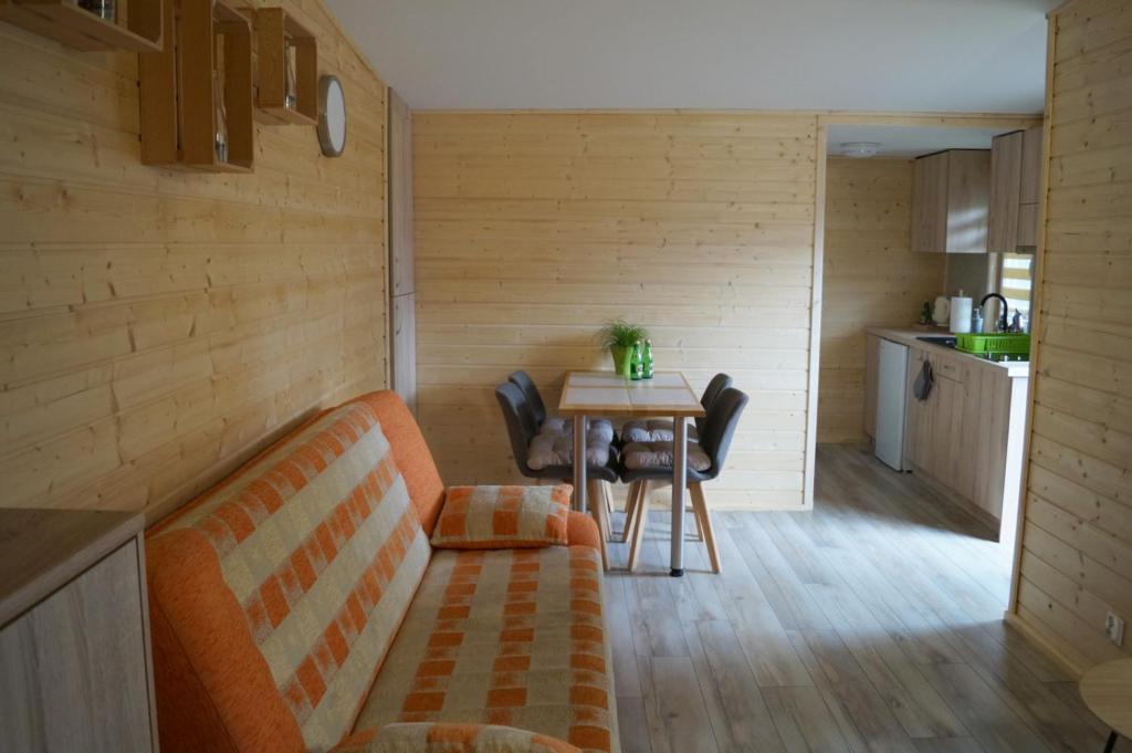 a living room with a couch and a table at Pogodny Domek in Mielno