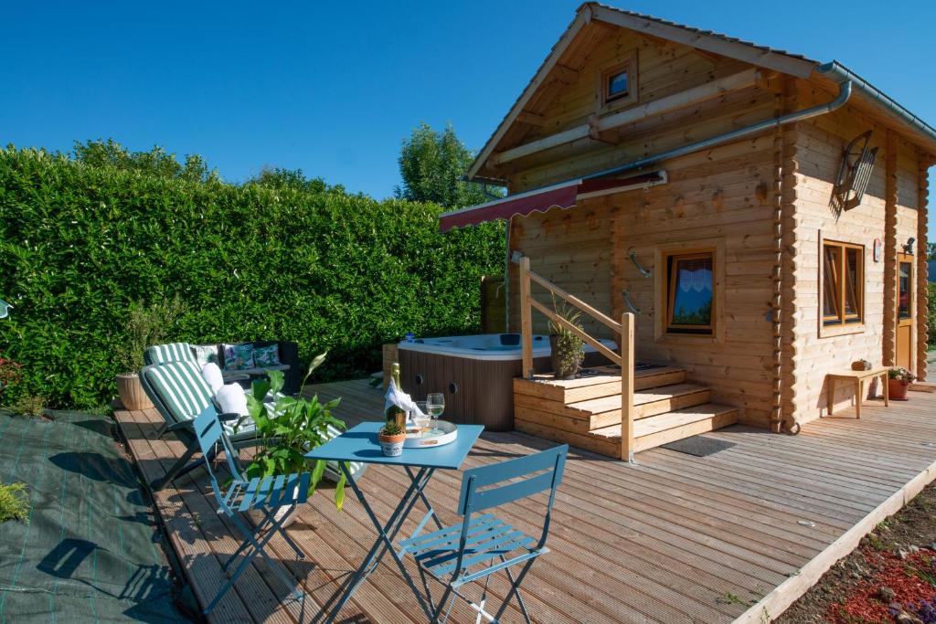 een kleine houten hut met een tafel en stoelen op een terras bij Chalet & SPA sur la Côte Fleurie in Auberville