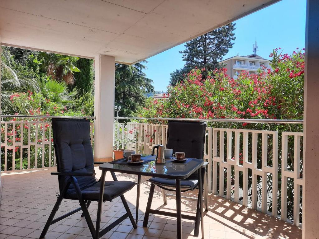 a patio with two chairs and a table on a balcony at Marion apartment in Portorož