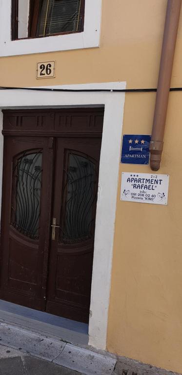 a pair of doors on a building with a sign on it at Apartment Rafael in Senj