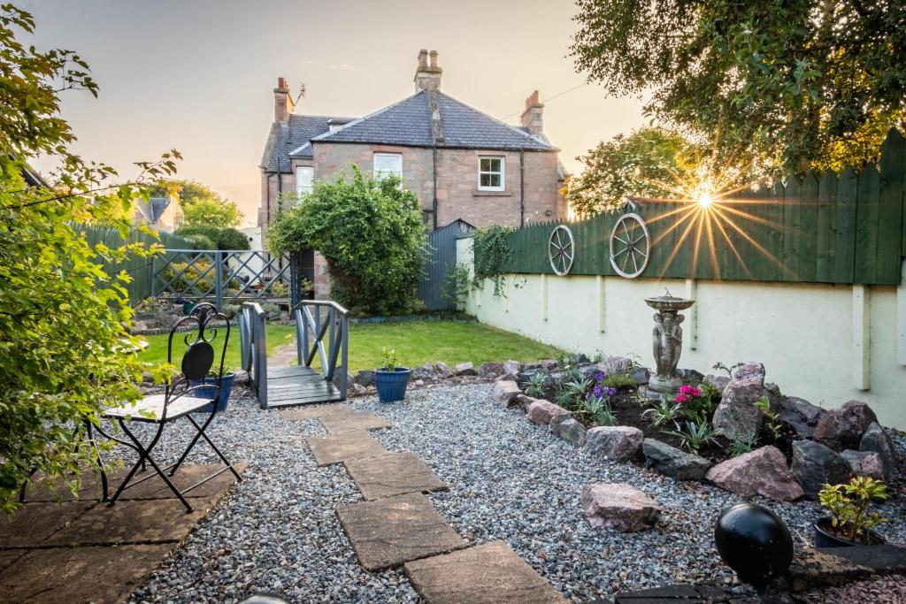 a backyard with a fence and a garden at West of the Ness - City Centre Home with 5 Bedrooms in Inverness