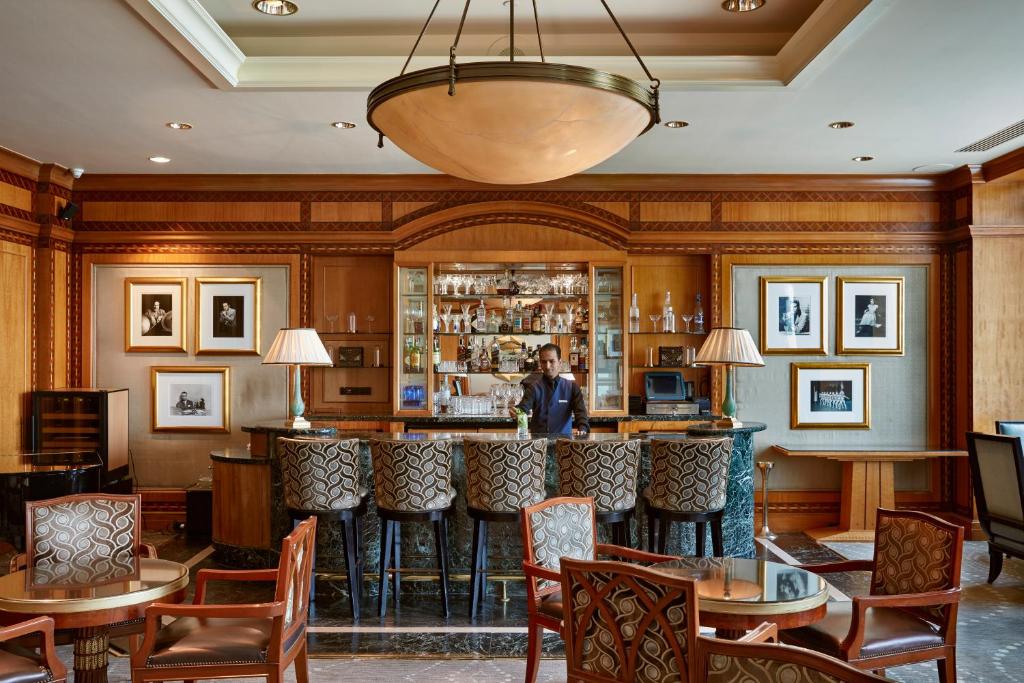 a man standing behind a bar in a restaurant at Four Seasons Hotel Cairo at Nile Plaza in Cairo