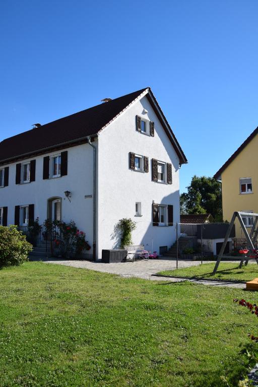 a white house with a playground in front of it at Ferienhaus Pusteblume in Leutkirch im Allgäu