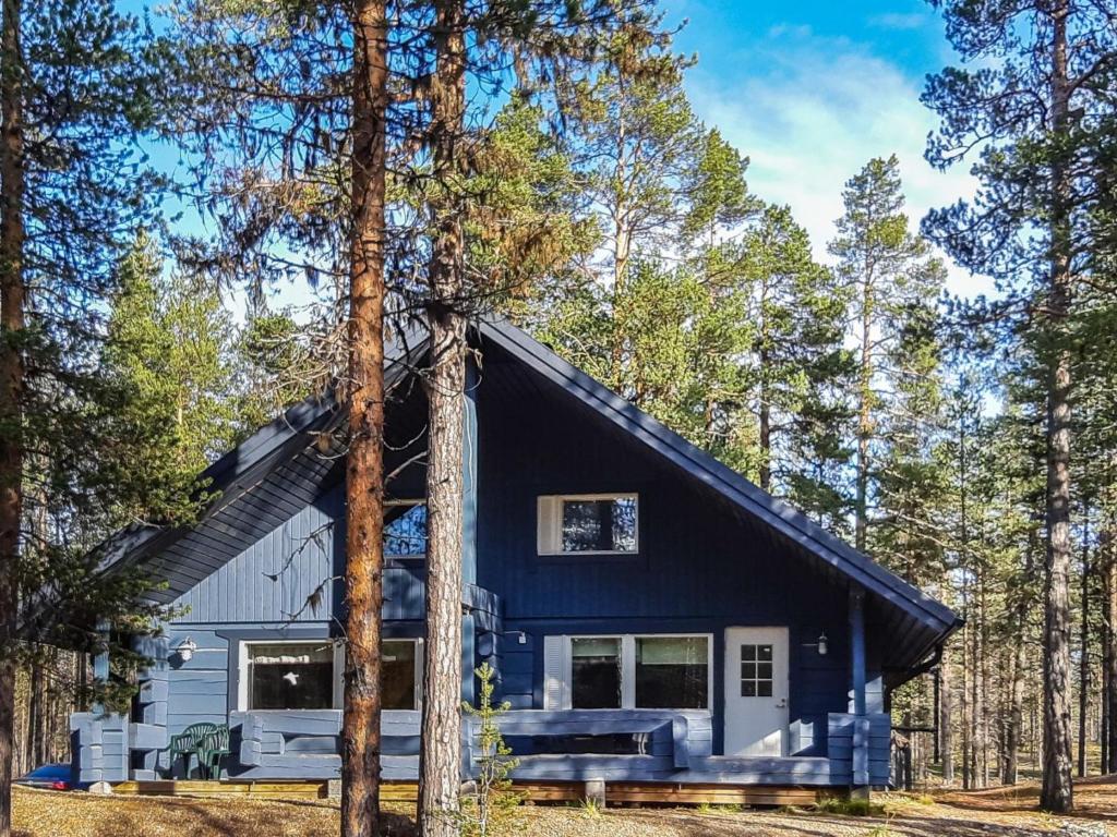 a blue house in the middle of the forest at Holiday Home Antin mökki by Interhome in Ylikyro