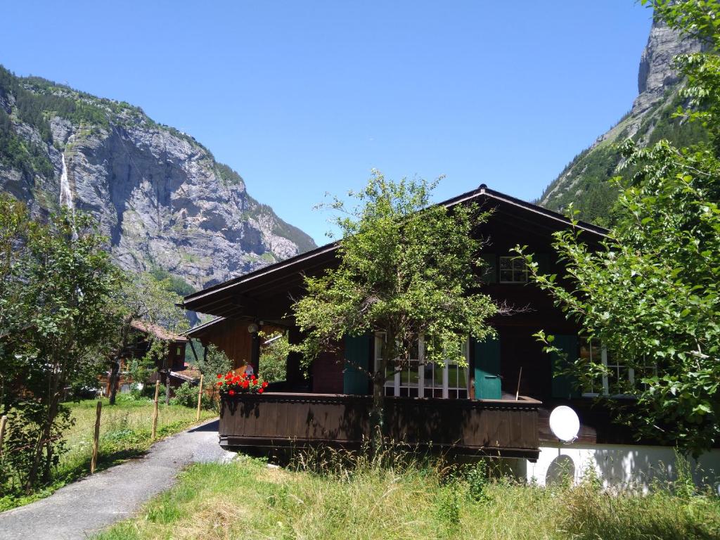 una casa su una strada con montagne sullo sfondo di Ferien Cottage Flüehblüemli a Stechelberg