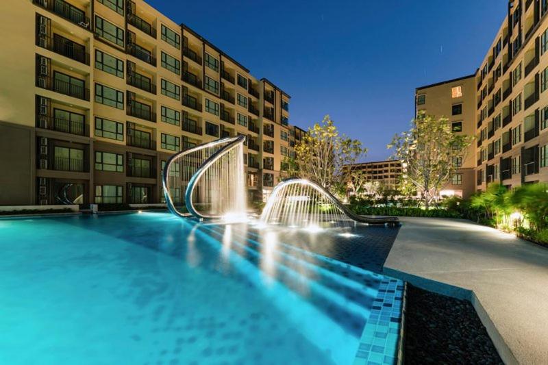 a swimming pool in front of a building at Rain cha-am by J in Cha Am