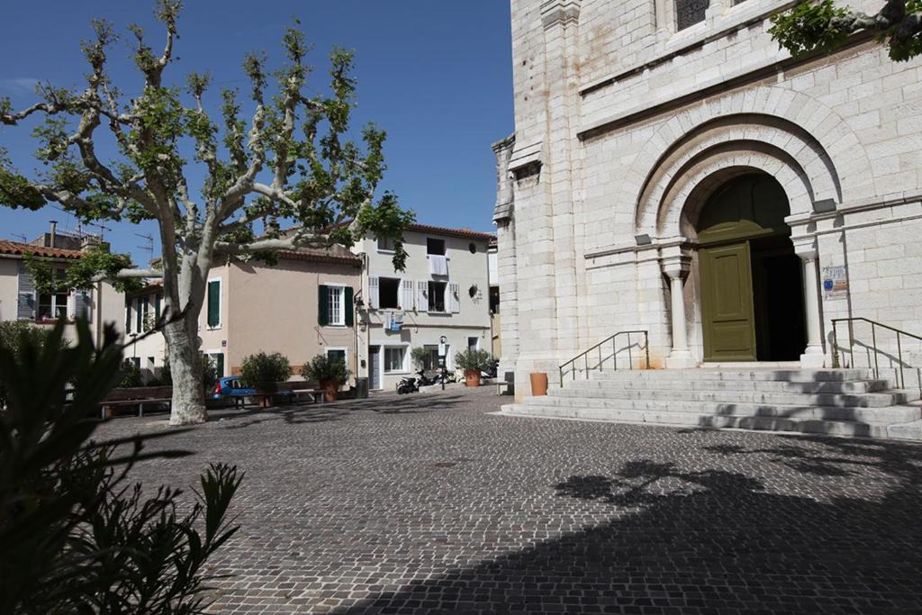 budynek z żółtymi drzwiami na ulicy w obiekcie Les Platanes w Cassis