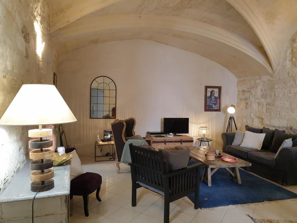 een woonkamer met een bank en een tafel bij Arles Rental-Côté Forum. in Arles