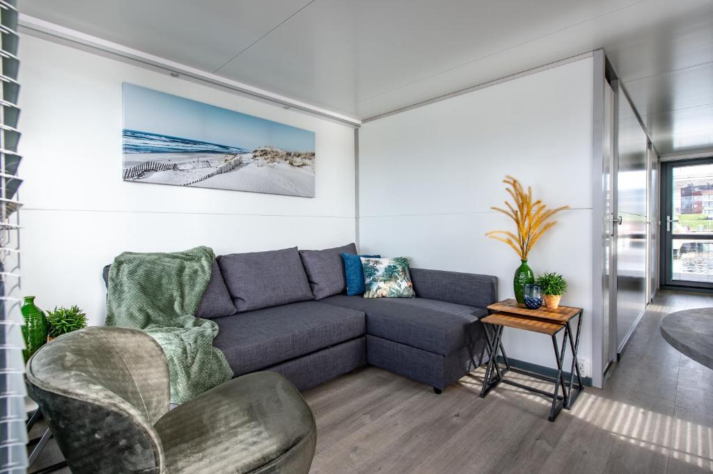 a living room with a couch and a table at Waterlodges Veerse Meer in Kamperland