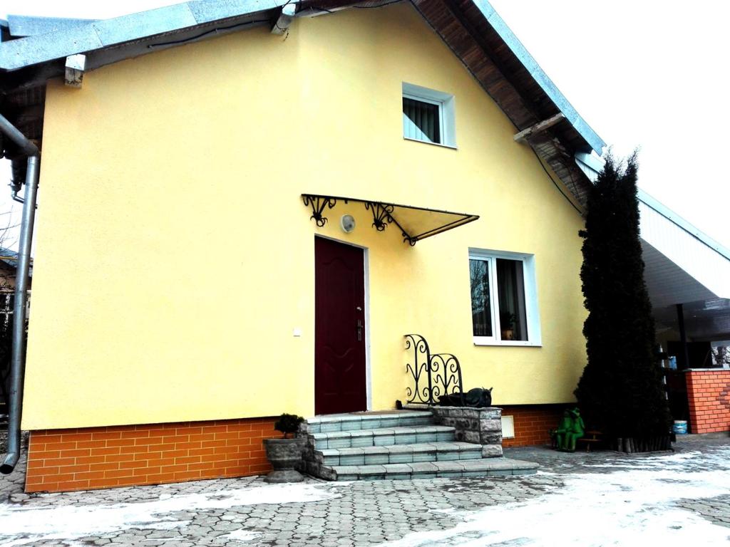 ein gelbes Haus mit Treppe und Tür in der Unterkunft VirDi House in Morschyn
