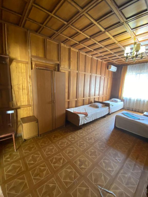 an empty room with two beds and a window at Guest House Mikhail in Adler