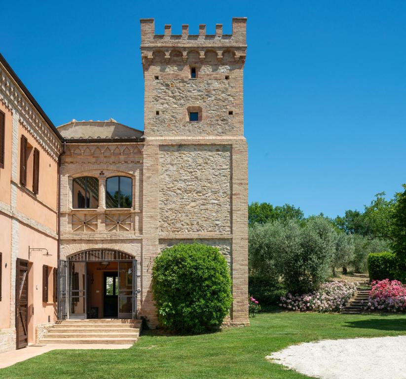 un grande edificio in mattoni con una torre di Fonte Sala a Montefalco