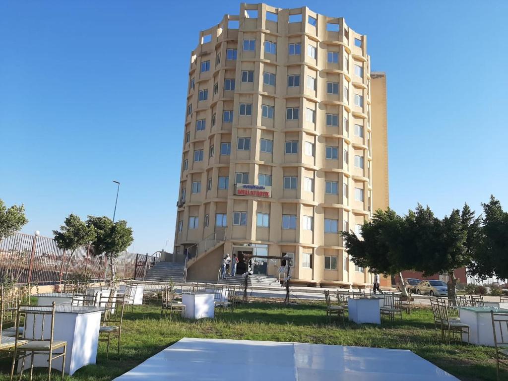 un edificio con una cancha de baloncesto delante en Royal NJ Hotel en Borg El Arab