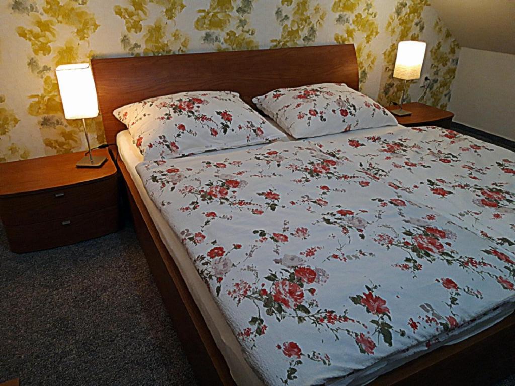 a bedroom with a bed with red flowers on it at JI APARTMENT crossroads D1,D2,D52 in Modřice