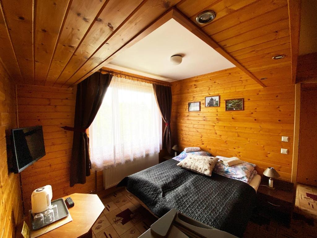 a bedroom with a bed in a wooden room at Willa Światowid in Rabka-Zdrój