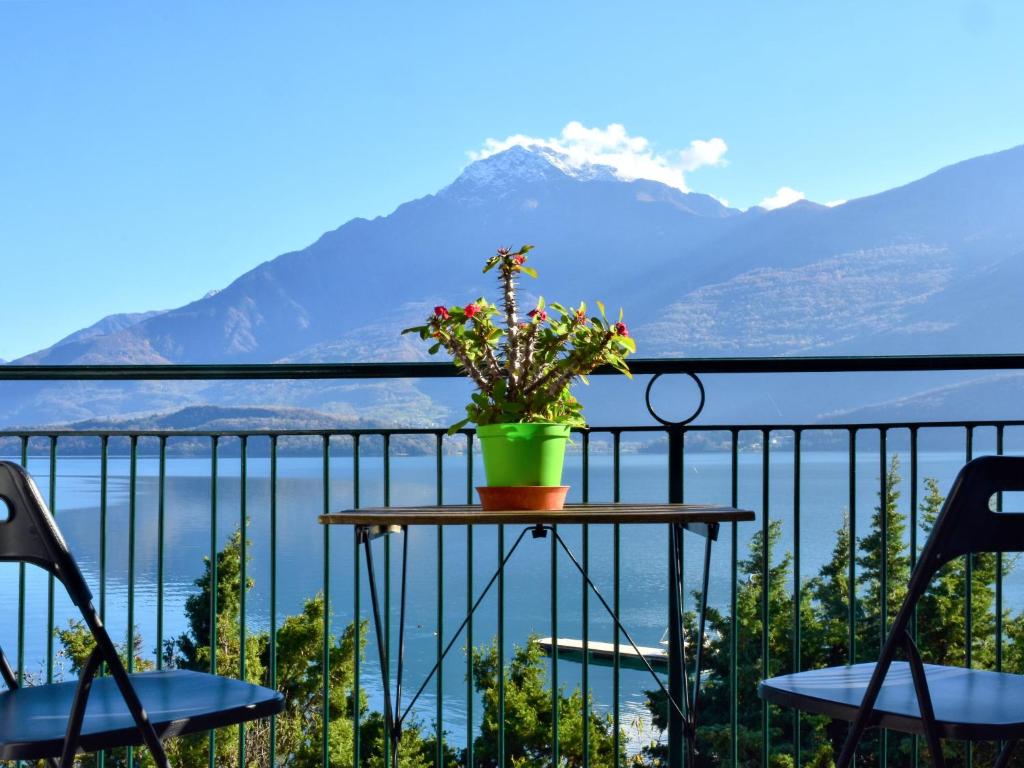 uma mesa com flores numa varanda com montanhas em Apartment Serenella by Interhome em Gravedona