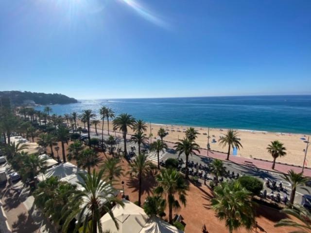 a view of a beach with palm trees and the ocean at Mediterranean apartment in Lloret de Mar next to the Sea in Lloret de Mar
