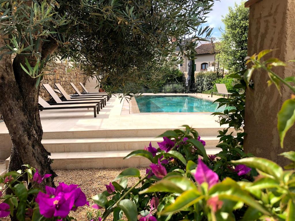 einen Pool mit Bänken und lila Blumen in der Unterkunft Villa Anna in Begur