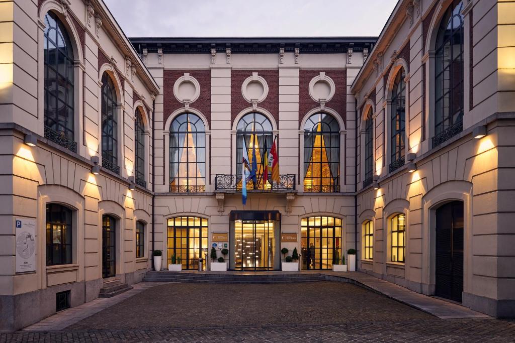 - un grand bâtiment avec de nombreuses fenêtres et lumières dans l'établissement Van Der Valk Sélys Liège Hotel & Spa, à Liège