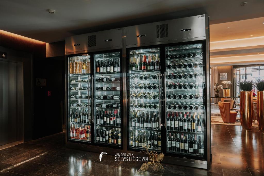 a room with two refrigerators filled with bottles of wine at Van Der Valk Sélys Liège Hotel &amp; Spa in Liège