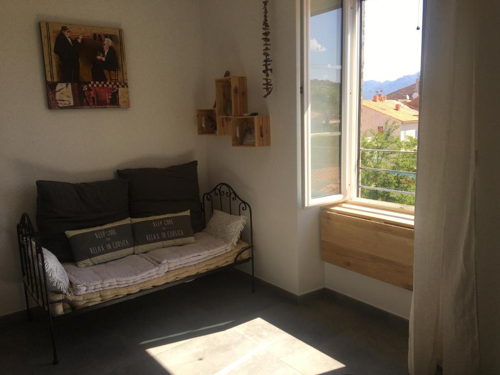 uma sala de estar com um sofá e uma janela em CasaRadriimas, un cocon au cœur du Centre Ville em Propriano