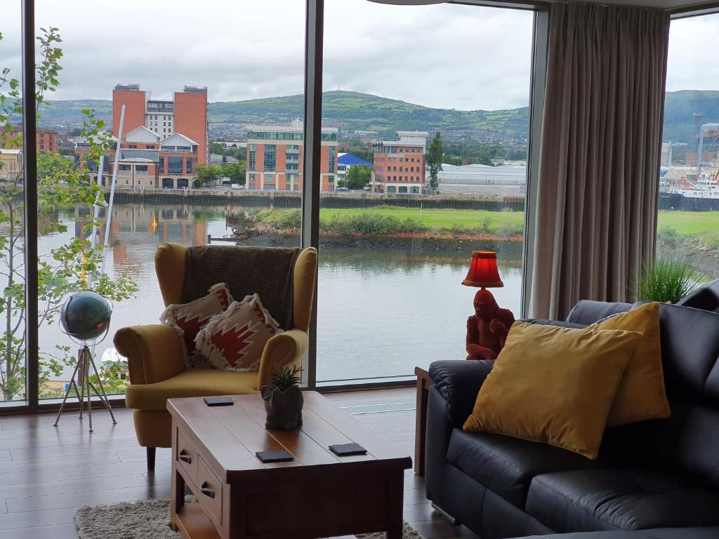 a living room with two couches and a large window at Luxury Apartment Marina Views at Titanic Quarter in Belfast