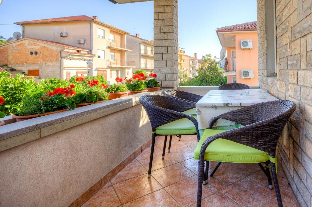 balkon z krzesłami, stołem i kwiatami w obiekcie Diconi w Puli