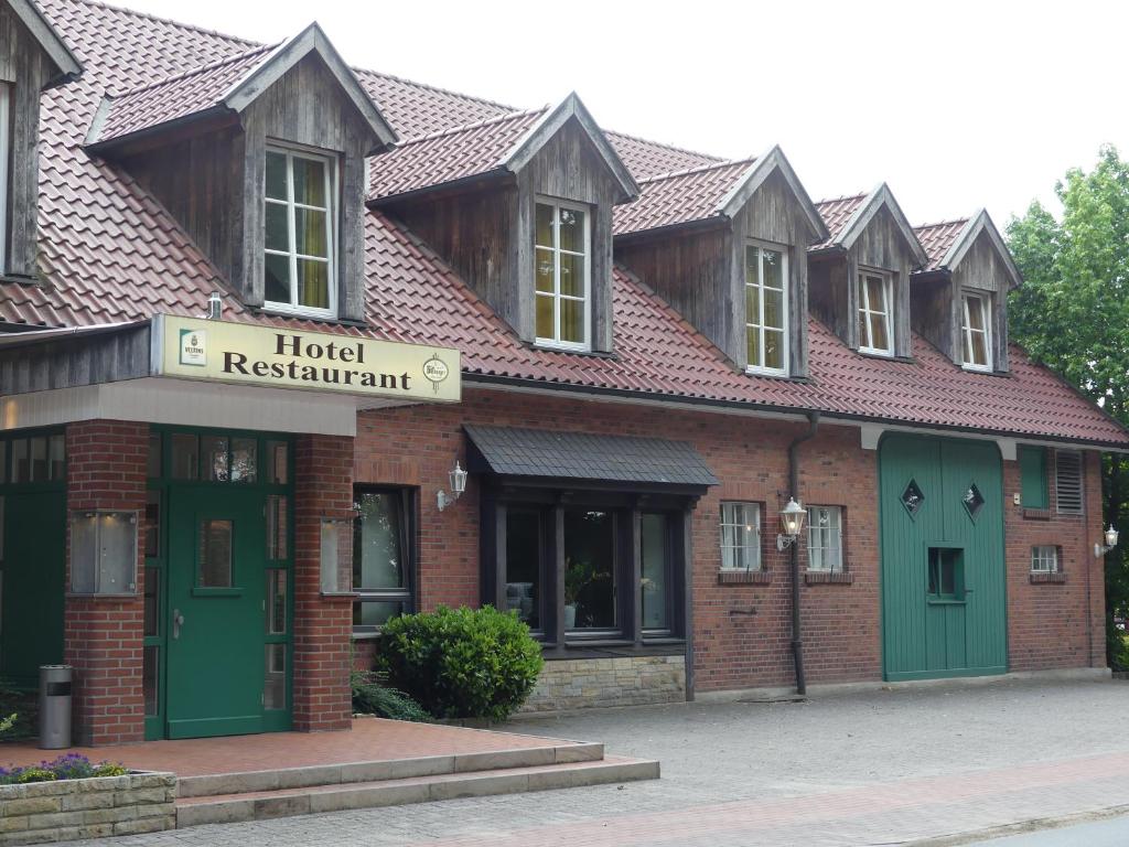 ein Hotelrestaurant mit grünen Türen in einem Backsteingebäude in der Unterkunft Landgasthaus Hotel Eggert in Rheine