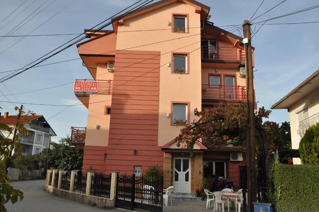un grand bâtiment avec une clôture devant lui dans l'établissement Apartments Joce, à Ohrid