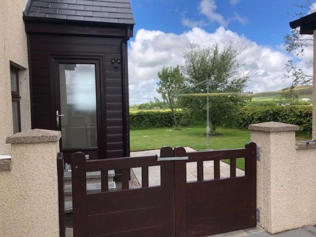 um portão de madeira em frente a uma casa em Luxury Flat with Lovely views in Rural location em Fraserburgh
