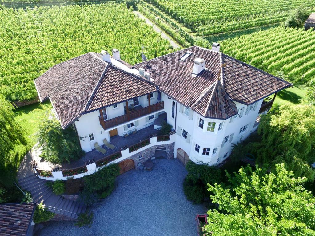 uma vista aérea de uma grande casa branca com um quintal em Weinhof Mumelter em Appiano sulla Strada del Vino