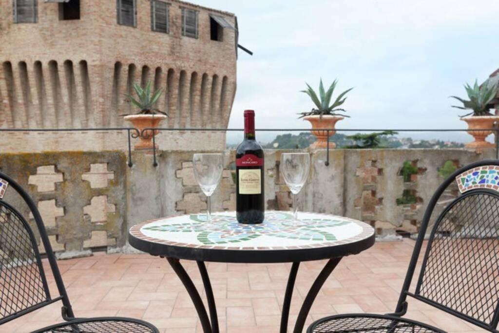 una botella de vino sentada en una mesa con dos copas en Casa Vacanze Wellness La Rocca, en Mondavio