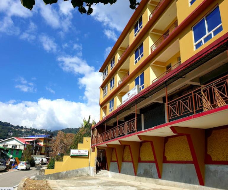 un bâtiment jaune avec des balcons sur son côté dans l'établissement Bankhim Residency (Parking available), à Gangtok