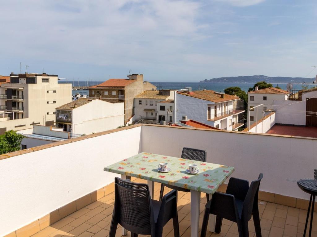 a table on a balcony with a view of a city at PORT III Sistach Rentals in L'Estartit