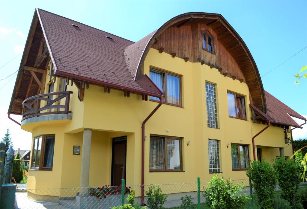 a large yellow house with a brown roof at Rozsi Mama in Sovata