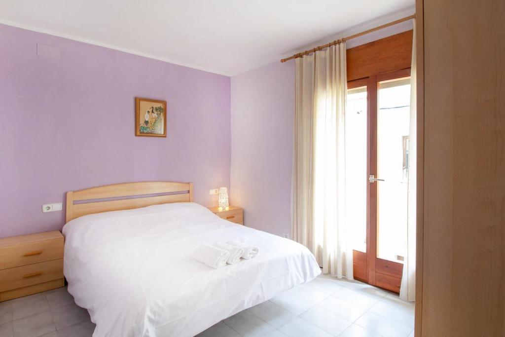 a bedroom with a white bed and a window at PORT I Sistach Rentals in L'Estartit