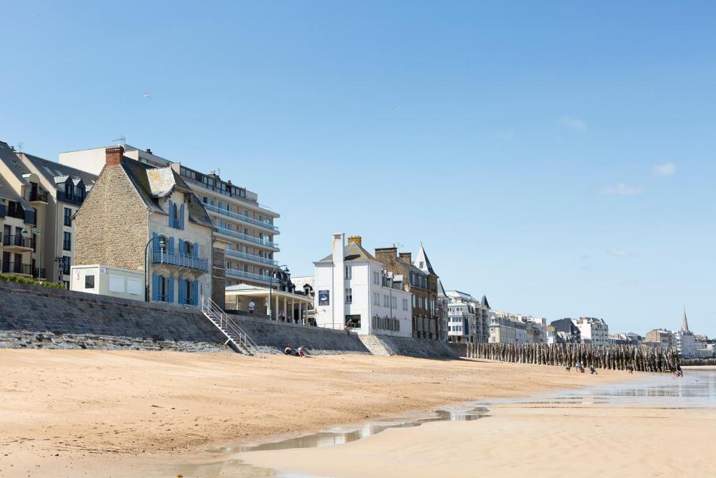 een uitzicht op het strand met gebouwen en appartementen bij La Villa ker Alexis by Cocoonr - Villa Balnéaire dans Saint-Malo in Saint-Malo