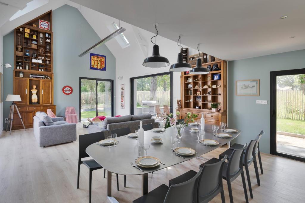 uma sala de jantar e sala de estar com mesa e cadeiras em Villa Epicure by Cocoonr - Belle maison proche de la plage em Saint-Lunaire