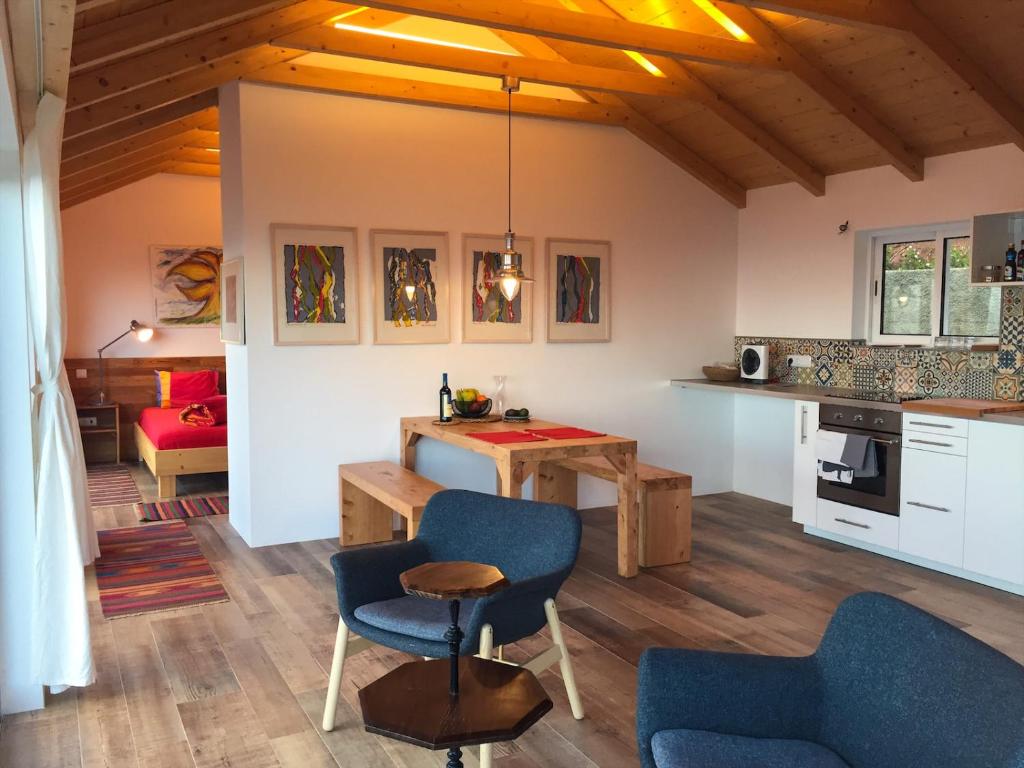 a kitchen and living room with a table and chairs at Quinta dos Artistas in Santa Cruz