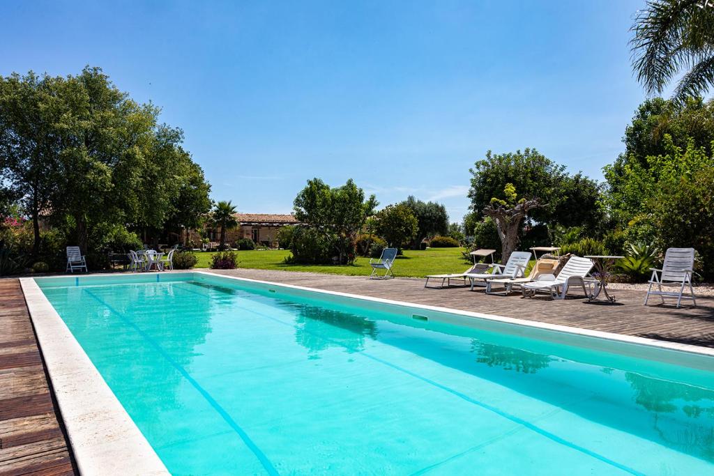 a large swimming pool with chairs and a table at B&B Madre Vita in Belvedere