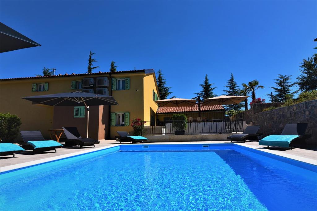 uma piscina em frente a uma casa em Letorina rooms and apartments with pool em Matulji