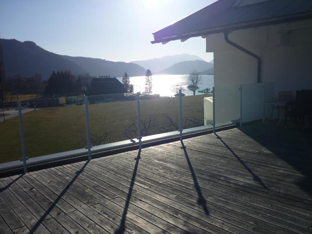 a deck with a view of the water and a house at Fewo Ossiach in Ossiach