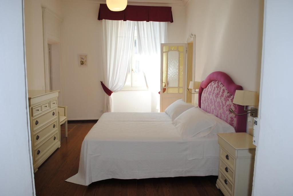 a bedroom with a large white bed and a window at Suite Villa Lillia in Bellagio