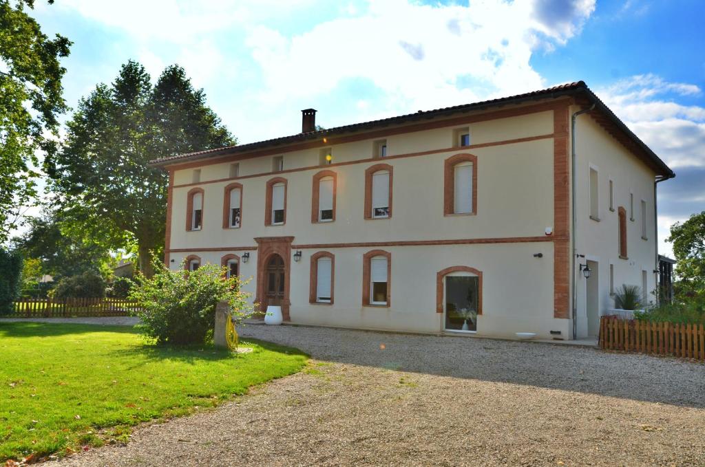 una gran casa blanca con una valla y un patio en Ô gré des sens, en Coufouleux