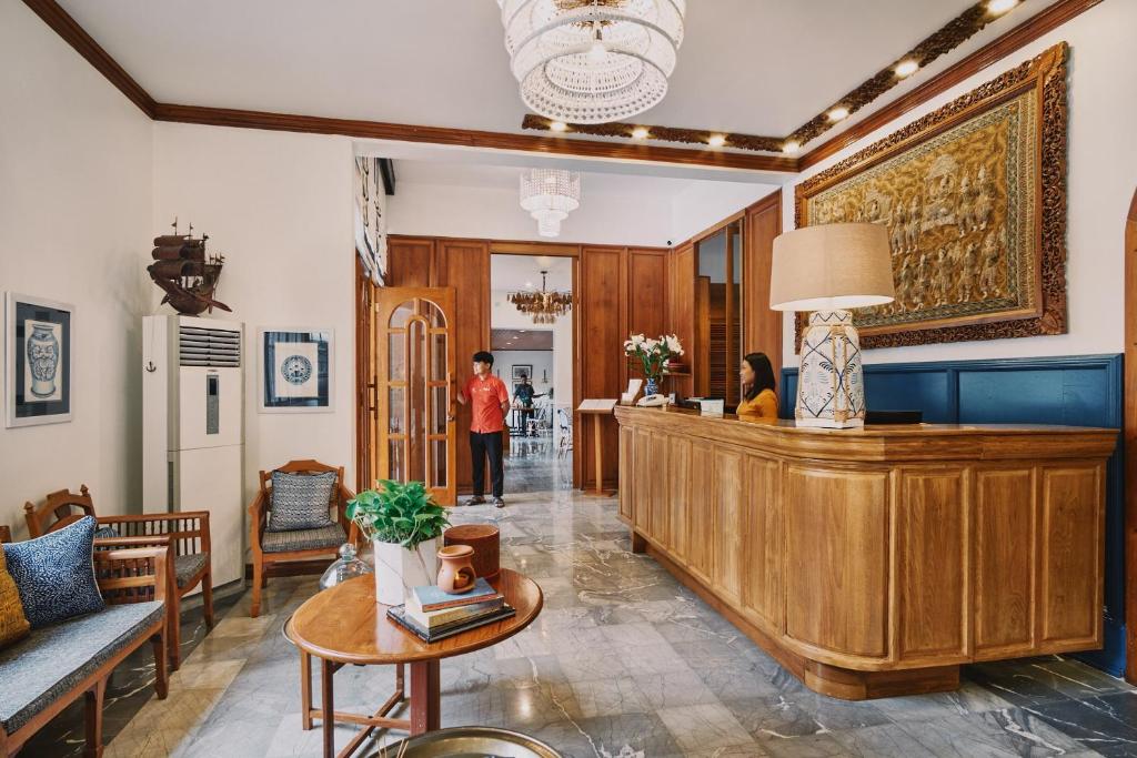 a lobby with a counter and a person standing in a room at Winner Inn in Yangon