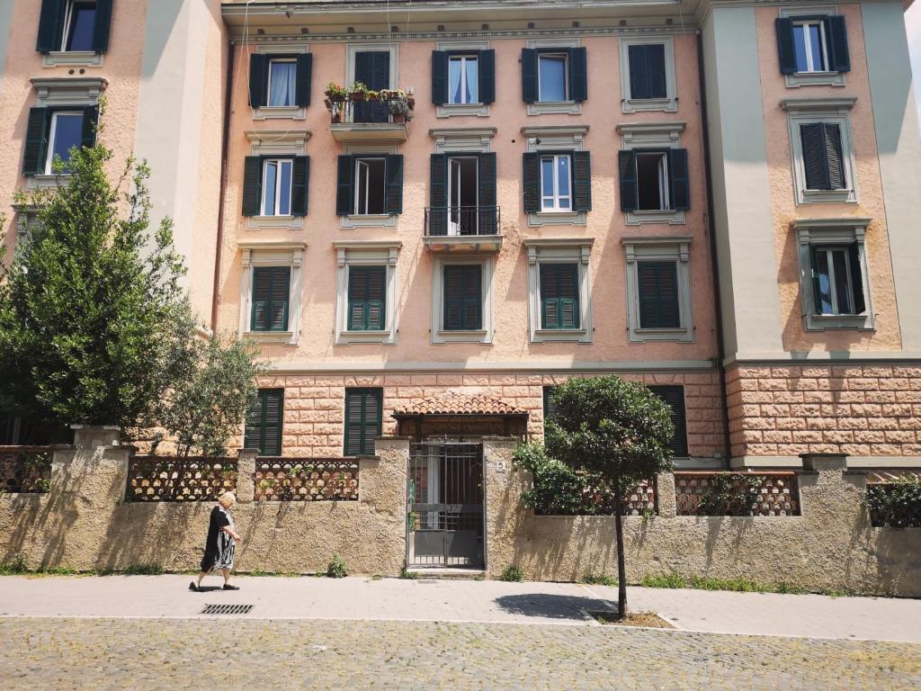 uma pessoa andando em frente a um grande edifício em Relais Villa Fiorelli em Roma